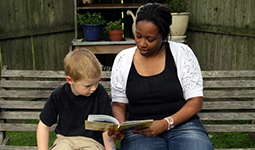 boy leaning to read with adult